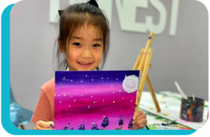 A child smiling and holding up a colorful painting.